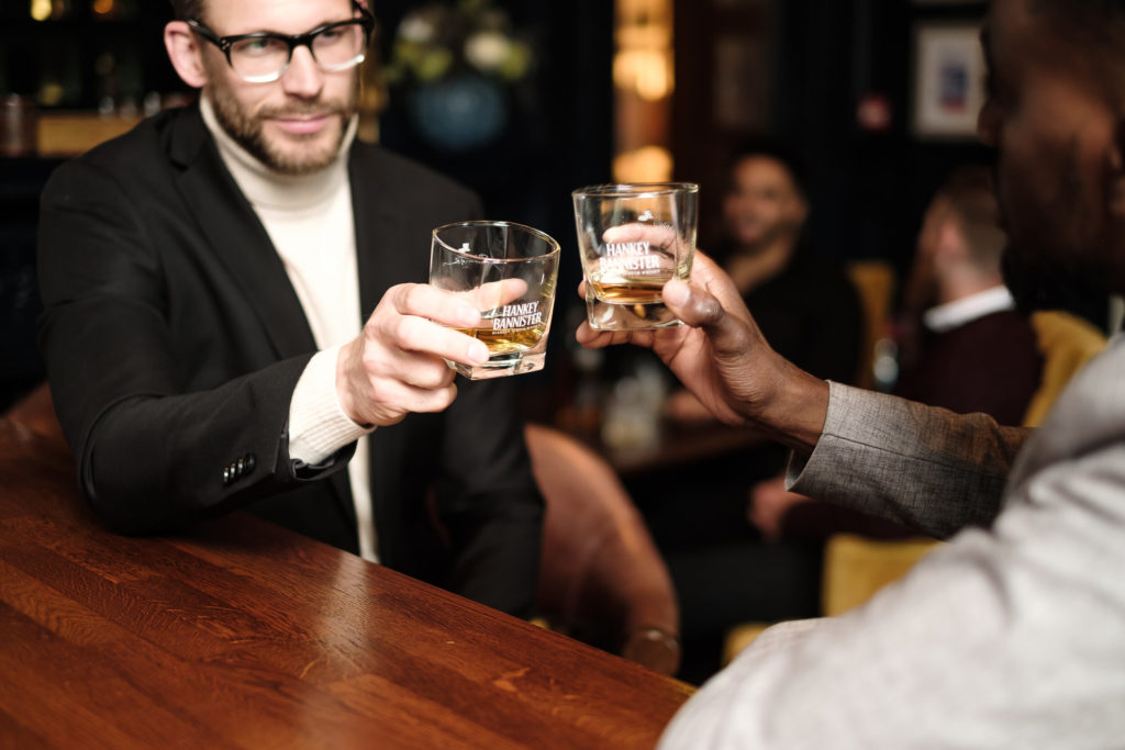 men drinking whisky in a bar